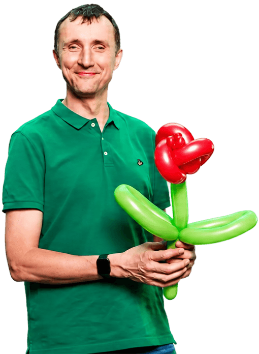 Een persoon in een groene poloshirt houdt een bloem die is gemaakt van rood en groen ballonmateriaal tegen een neutrale achtergrond.